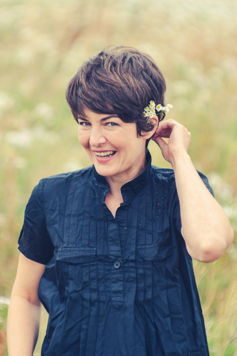 Lebendiges Outdoor-Künstlerportrait einer Schauspielerin mit Blumen im Haar
