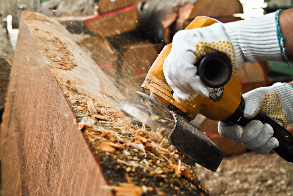 Unternehmensfotografie: Das Entfernen der Baumrinde mit einem Winkelschleifer in einem Holzverarbeitungsbetrieb © Alexandru Bialis, Unternehmensfotograf