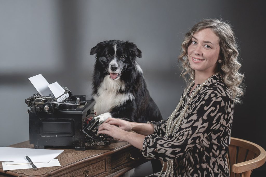 Vintage-Porträt im 1920er Stil mit sitzender Frau und Hund, Blick zur Kamera