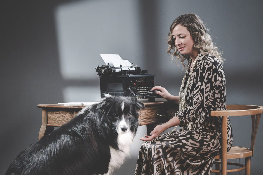 Horizontales Vintage-Porträt mit Frau und Hund im Fotostudio