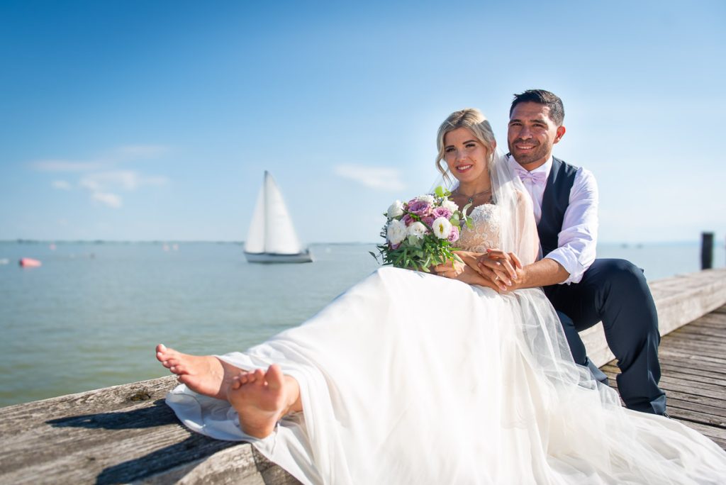 Brautpaar bei einem Hochzeitsfotoshooting am Neusiedler See im Burgenland in Österreich – romantische Hochzeitsfotografie auf einem Steg